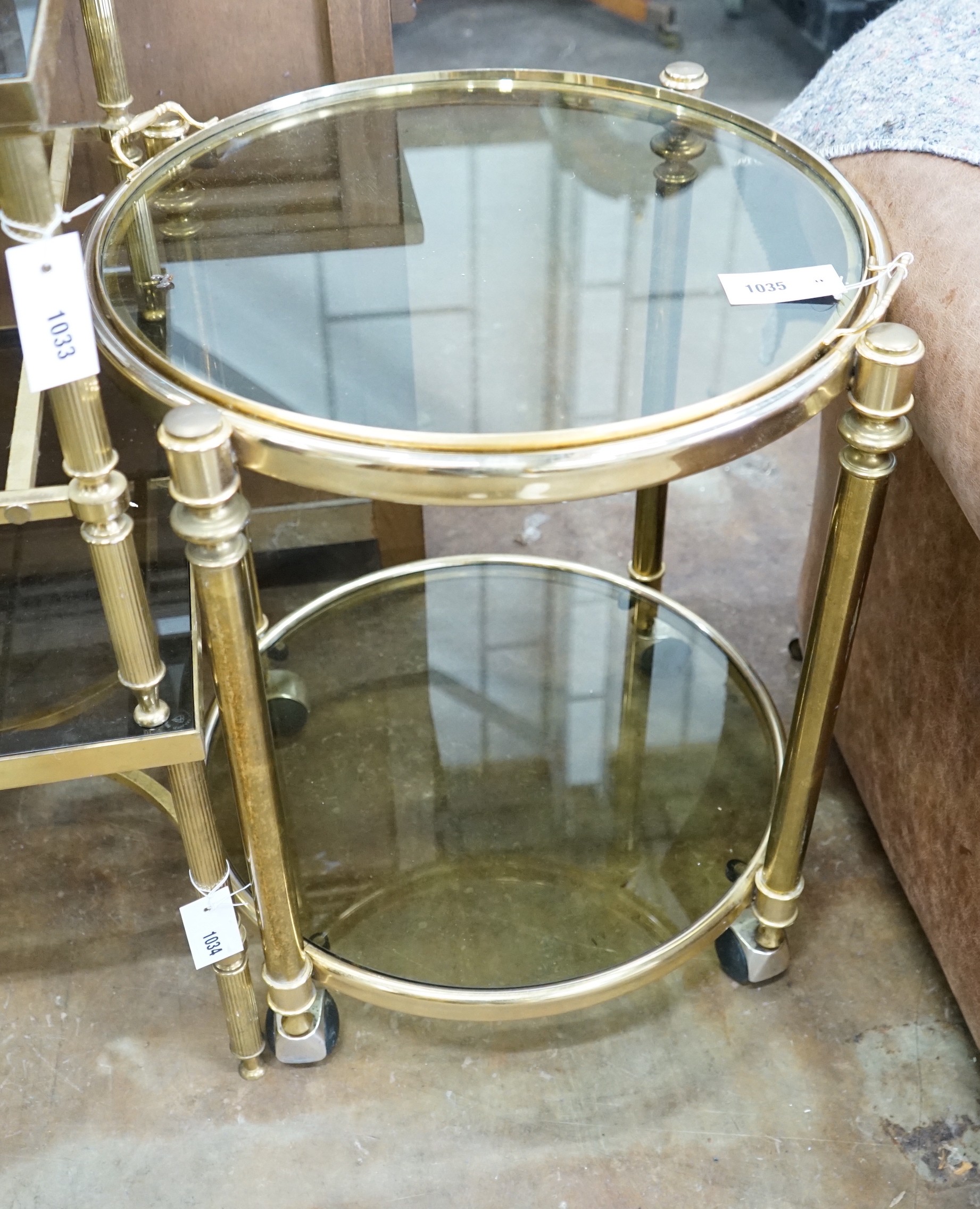 A circular smoked glass and brass tray top two tier occasional table, diameter 57cm, height 64cm